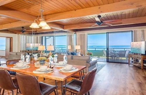 a dining room with a table and a living room at Coastal Paradise Condo with Panoramic Ocean Views in Kahana