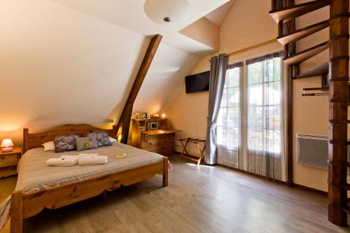 Un dormitorio con una cama y una ventana grande. en Logis Hôtel Restaurant Auberge du Bougnat, en St Victor la Riviere