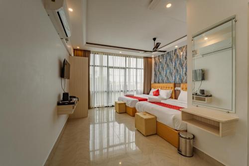 um quarto com duas camas e uma janela grande em Priya Residency Pondicherry em Pondicherry