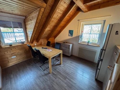 a dining room with a table and two windows at Ferienwohnung zum Kirchturmblick in Dettelbach