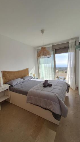 a bedroom with a large bed and a large window at Amplio Adosado 160 m, jardín privado barbacoa, vistas al mar, wifi 7 px mascotas in Peñíscola