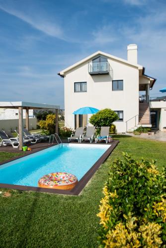 a villa with a swimming pool in front of a house at Viana Fishers House - Pool & Beach ! in Viana do Castelo