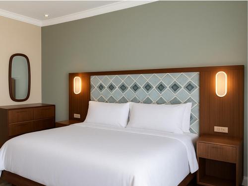 a bedroom with a large white bed and a mirror at Marriott Vacation Club, Waikīkī- 1 BEDROOM in Honolulu