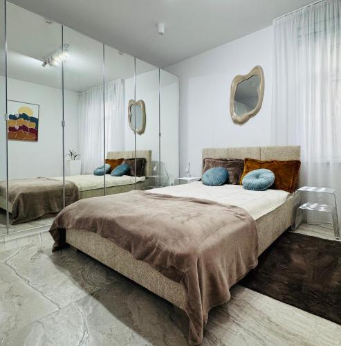 a bedroom with a large bed with mirrors on the wall at Pastello & Bianco in Biskupiec