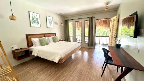 a bedroom with a bed and a table and a desk at Aulea Siargao in General Luna