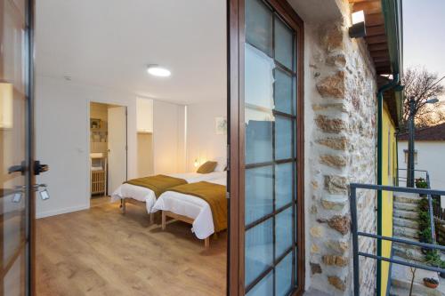 Un dormitorio con una cama y una puerta de cristal. en Df Alojamentos e Suites, en Eiras