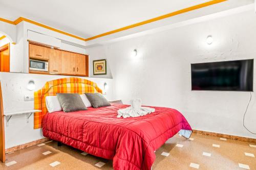 a bedroom with a red bed and a tv at Unique hotel apartment 1-2 in Torrevieja