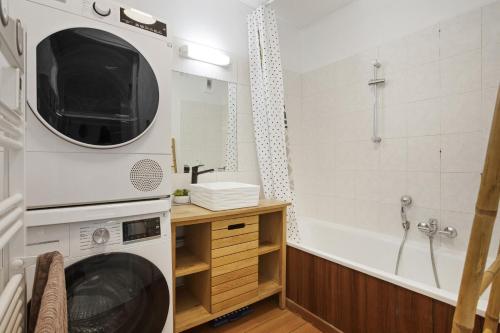 ein Badezimmer mit Badewanne und Waschmaschine in der Unterkunft Un Havre De Paix in Fréjus