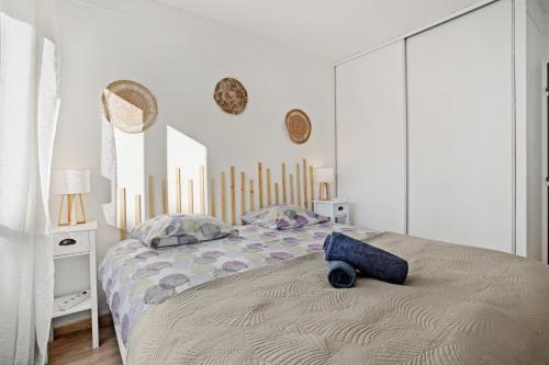 ein Schlafzimmer mit einem Bett mit einem blauen Kissen darauf in der Unterkunft Un Havre De Paix in Fréjus