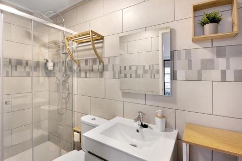 Un baño con lavabo, inodoro y espejo. en Df Alojamentos e Suites, en Eiras