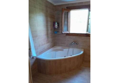 a bath tub in a bathroom with a window at Tsarouxi village 2 in Drakótrypa