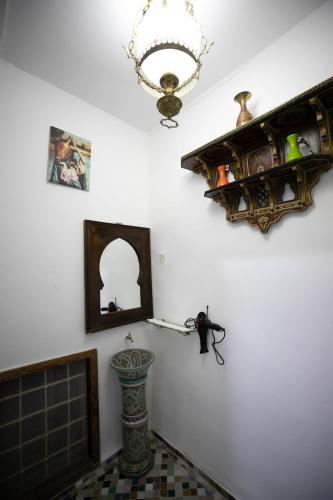 a room with a fireplace and a chandelier on the wall at Dar El Kendil in Fez