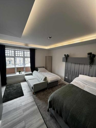 een slaapkamer met 2 bedden en een bank bij Resilets - Mood Studio 2 - Central Modern 2 Bed in Bedlington