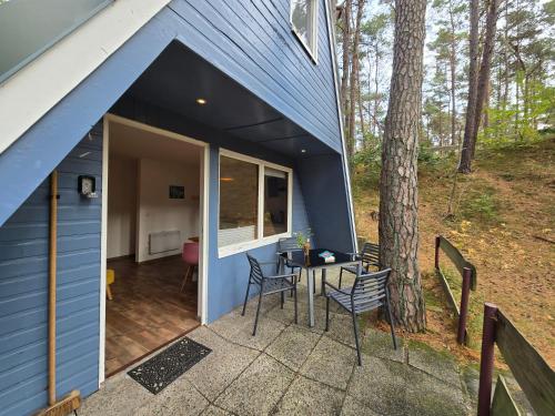 una casa blu con patio dotato di tavolo e sedie di Finn-Max a Zinnowitz