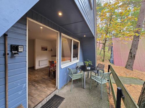 una piccola casa blu con tavolo e sedie di Finn-Frieda a Zinnowitz