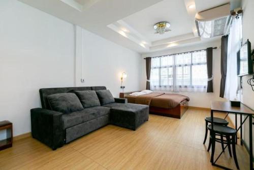 un soggiorno con un divano e un letto di Taladnoi Paint House a Bangkok