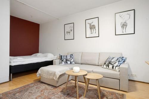 a living room with a couch and a bed at Cozy Studio, Free Parking By Lapland Host in Rovaniemi