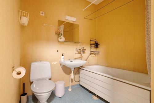 a bathroom with a toilet and a sink and a tub at Cozy Studio, Free Parking By Lapland Host in Rovaniemi