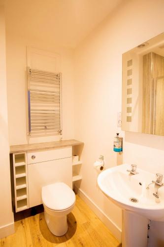 a bathroom with a white toilet and a sink at Poseidon's in Lossiemouth