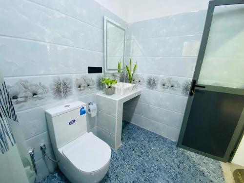 a white bathroom with a toilet and a sink at Sea Path Villa - Dikwella in Dickwella