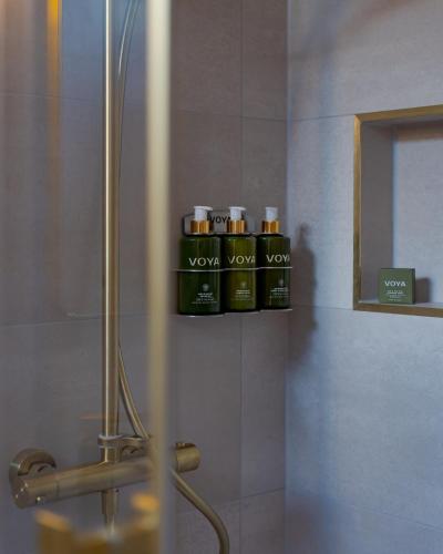 a bathroom with four bottles of oils on a shelf at Rooms at 32 in Sligo