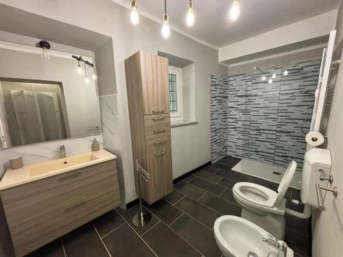 a bathroom with a toilet and a sink and a mirror at La Quiete del Mattino in Torre Pellice