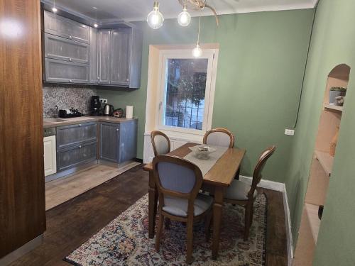 a kitchen with a table and chairs and a kitchen with green walls at La Quiete del Mattino in Torre Pellice