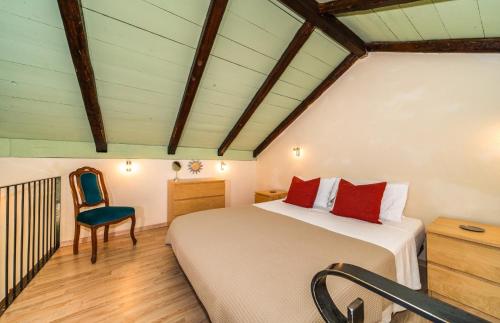 una camera da letto con un letto e una sedia in una stanza di Arethusa Cottage a Vathi