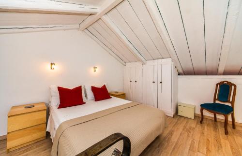 a bedroom with a large bed and a blue chair at Amalthia Cottage in Vathi, Ithaka