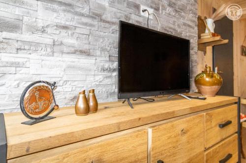 a flat screen tv sitting on top of a wooden dresser at Romy in Aillon-le-Jeune