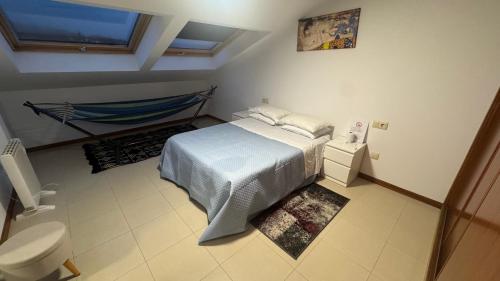 Un dormitorio con una cama y una hamaca. en Atico Finisterre, en Finisterre