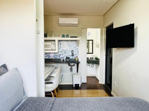 a small room with a bed and a bathroom at Pousada Maritimus in Barretos