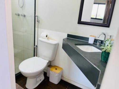 a bathroom with a toilet and a sink at Pousada Maritimus in Barretos