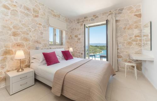 Villa Akoni في ميغانيسي: غرفة نوم بسرير وجدار حجري