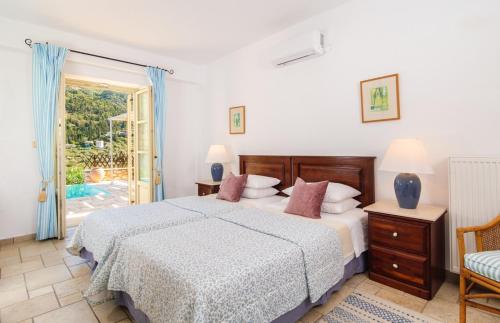een slaapkamer met een bed en een glazen schuifdeur bij Villa Athina in Ayios Nikitas