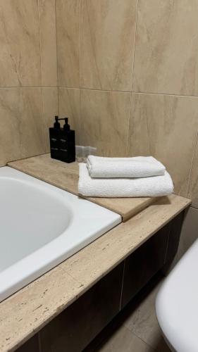 a bathroom with a sink and a bath tub with towels at Atico Finisterre in Fisterra