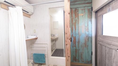 a bathroom with a sink and a toilet and a door at Asahi Seaside Cottage - Vacation STAY 42134v in Asahi