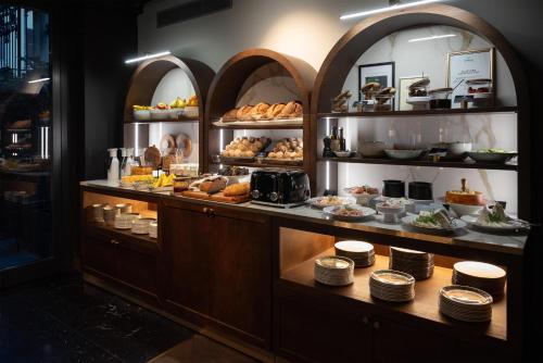 a bakery with a buffet of food on display at Palazzo Touring Club Milan, A Radisson Collection Hotel in Milan
