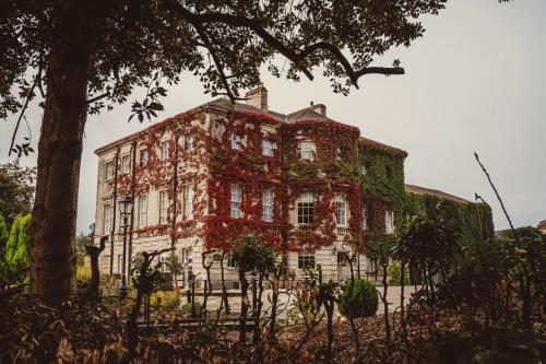 an old brick building with ivy growing on it at Aston Hall Hotel, BW Signature Collection in Sheffield