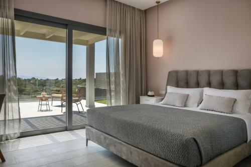 a bedroom with a bed and a balcony with a table at Villa Stellina in Karavádhos