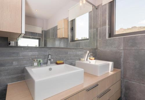 a bathroom with a white sink and a mirror at Villa Isidora in Sitia
