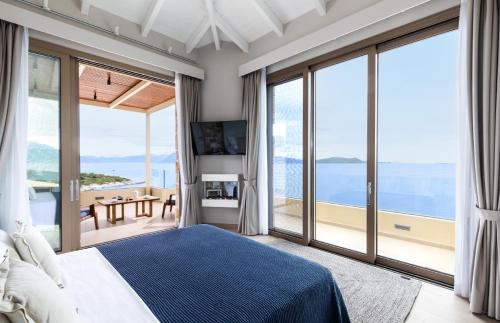 een slaapkamer met een bed en uitzicht op de oceaan bij Villa Noesis in Katomérion