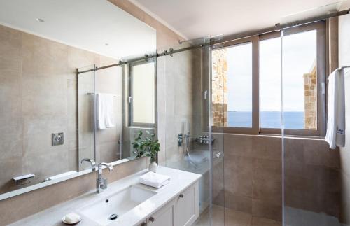 een badkamer met douche, wastafel en spiegel bij Villa Noesis in Katomérion