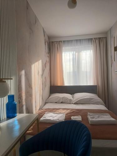a small bedroom with a bed and a window at Blue Royal Luxury Apartment z HBO Max in Tarnów