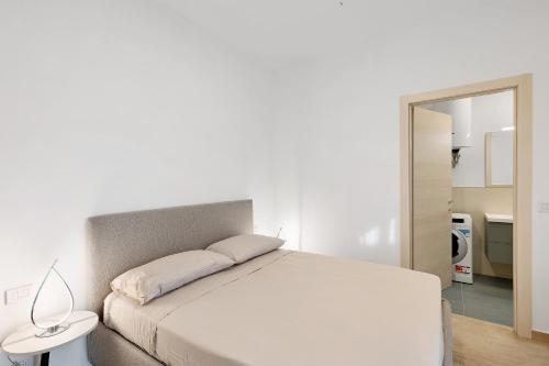 ein weißes Schlafzimmer mit einem weißen Bett und einem Spiegel in der Unterkunft Casa vacanze Cavalca l'Onda in Poggio