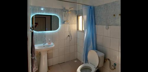 un bagno con un water, un lavandino e uno specchio di studio Zen 1 a Ziguinchor