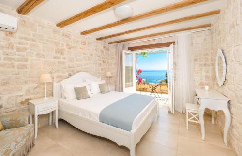 The Yiameli Collection - Yasmi في Skinária: غرفة نوم مع سرير وإطلالة على المحيط