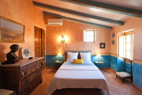 Un dormitorio con una cama, una cómoda y ventanas. en Le Maria Venezia, en LʼÎle-Rousse