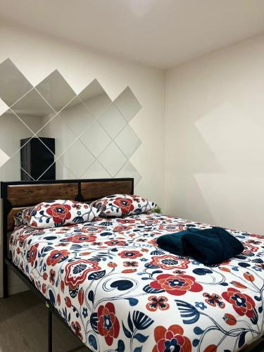 Appartements & Spa Orly Paris في فيلنوف سان جورج: سرير مع لحاف الزهور في غرفة النوم