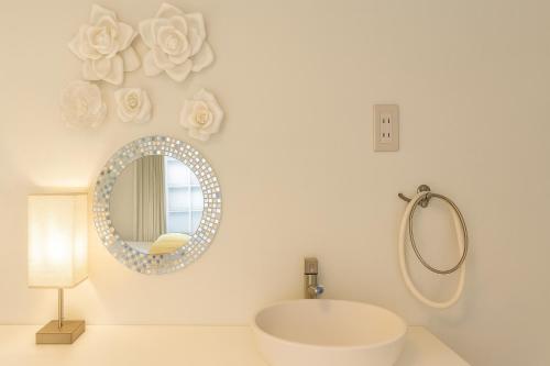 Honmachi Spacious Family Apartment 3min Walk from Station for 6 Guests 1008 في أوساكا: حمام أبيض مع مرآة ومغسلة